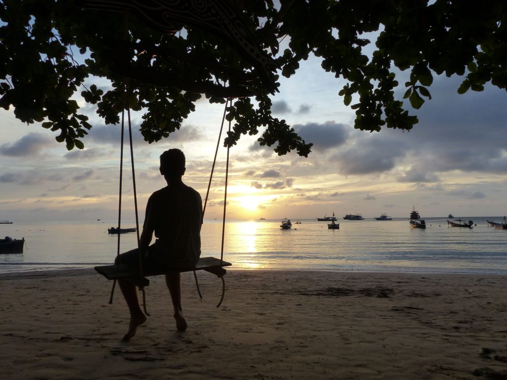Moi qui tape la pose sur une balançoire face à un coucher de soleil à Koh Tao