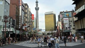Rue d’Asakusa animée avec la Tokyo Skytree en arrière-plan, entre tradition et modernité japonaise.